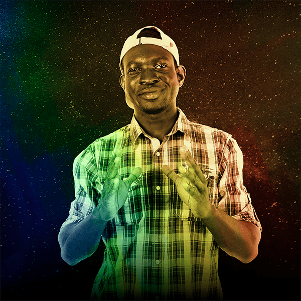 Mid-twenties and dark-skinned ensemble member, David Oppong, wearing a backwards hat, plaid shirt, and gesturing with his hands in a speaking fashion against a star background. The image is treated with a rainbow gradient to match the Robot Revelations album artwork.