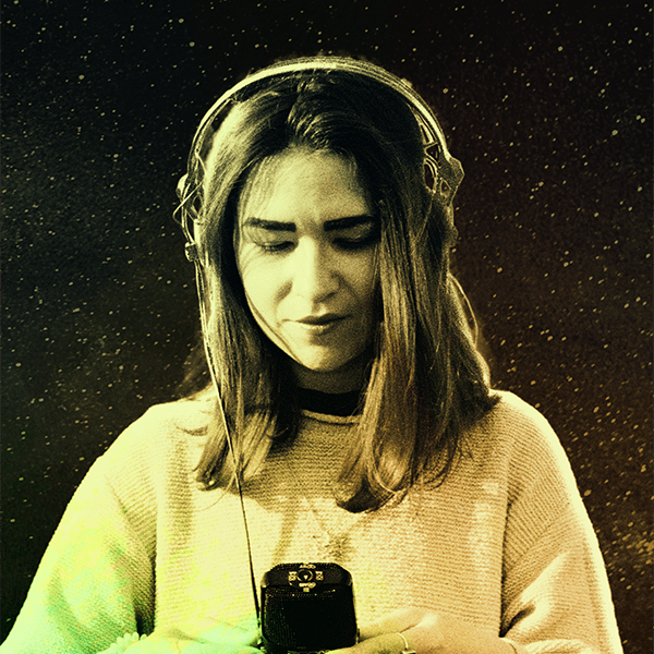 Guest producer, Stefana Fratila. Stefana is wearing a white sweater, headphones and has straight dark hair that goes down to her shoulders. She is looking down at a hand-held recorder she is holding with both hands and seems to be concentrated on the sounds she is capturing. Image is treated with a rainbow overlay to match the album artwork.